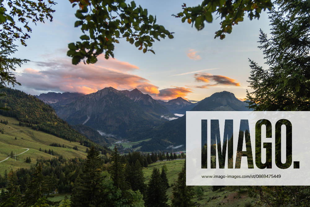 Autumn Evening in the Allgäu: The clouds in the sky glow in the evening sun above the peaks of the Allgäu Alps, Bad Hindelang, Bavaria, Germany