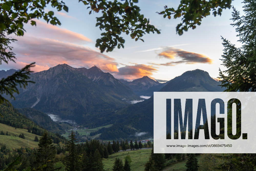 Autumn Evening in the Allgäu: The clouds in the sky glow in the evening sun above the peaks of the Allgäu Alps, Bad Hindelang, Bavaria, Germany