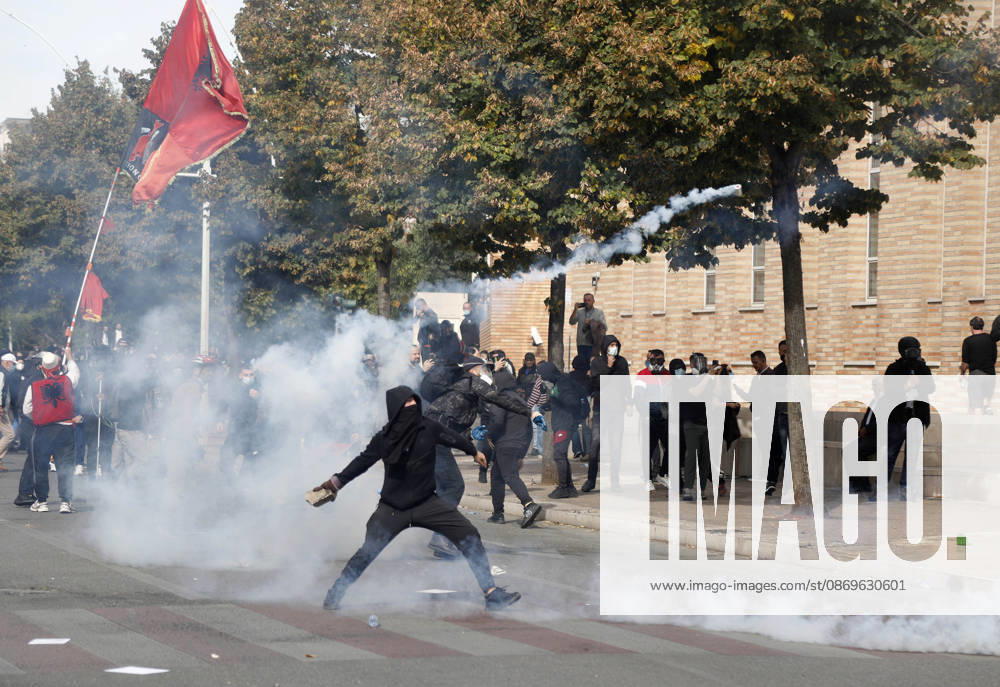 Protesters Clash with Police During a Demonstration in Tirana, Albania. Protesters hold an Albanian flag as they throw stones to riot police during an anti-government demonstration in central Tirana on October 15, 2026, as protests continued for a third consecutive day over university conditions and demands for the resignation of Albanian Prime Minister Edi Rama. The latest rally follows two nights of violence in the capital, during which protesters and riot police clashed, police used water cannons and tear gas, and demonstrators damaged government offices and shops and set fire to several buildings. Light Studio Agency Malton Dibra Tirana Albania