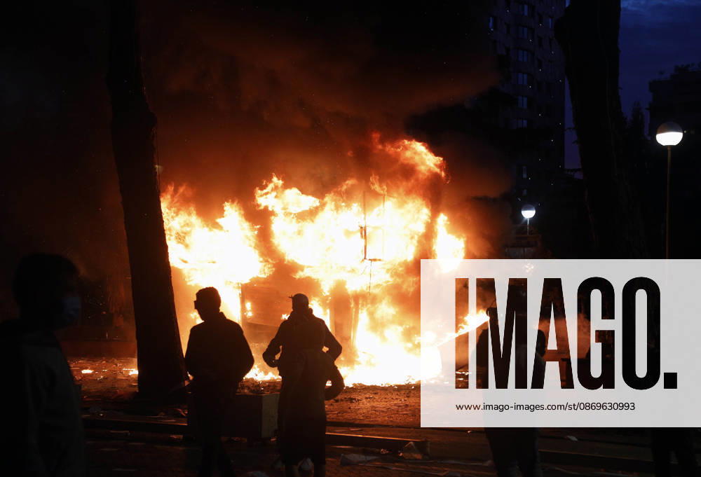 Protesters Clash with Police During a Demonstration in Tirana, Albania. Protesters walk in front of a burning kiosk during an anti-government demonstration in central Tirana on October 15, 2026, as protests continued for a third consecutive day over university conditions and demands for the resignation of Albanian Prime Minister Edi Rama. The latest rally follows two nights of violence in the capital, during which protesters and riot police clashed, police used water cannons and tear gas, and demonstrators damaged government offices and shops and set fire to several buildings. Light Studio Agency Malton Dibra Tirana Albania