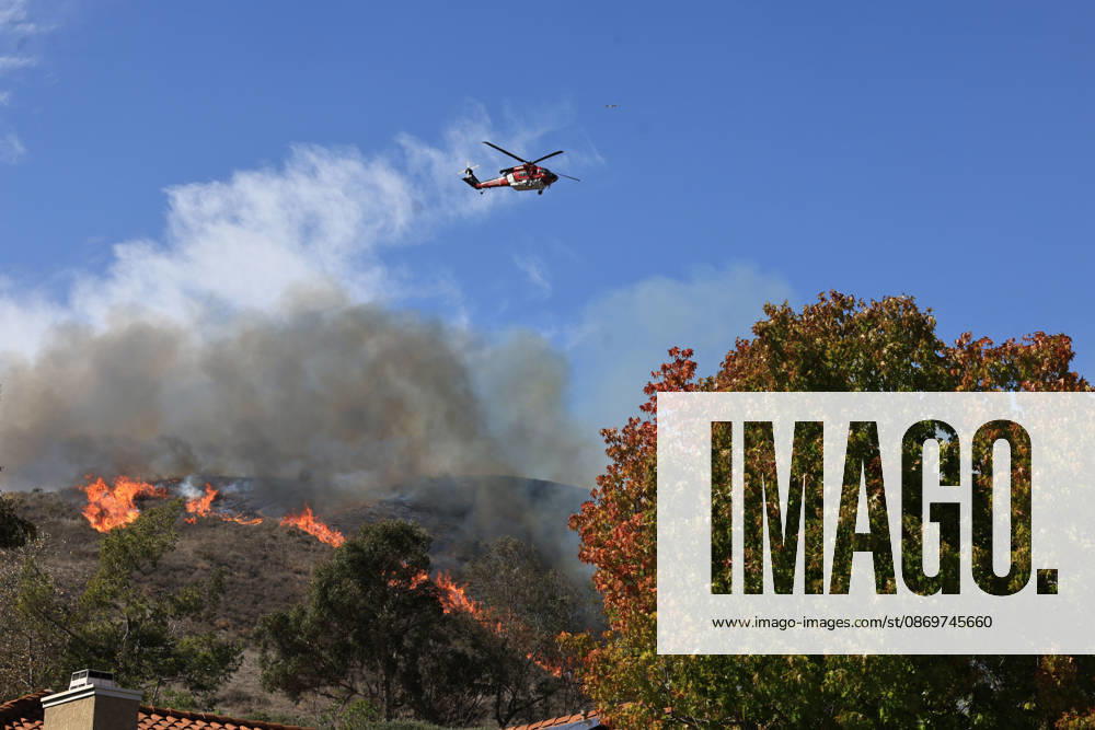 October16, 2026, San Juan Capistrano, California, USA: Fire crews are aggressively battling a wind-driven brush fire that burned several homes and threatened thousands of others in the area of San Juan Capistrano and San Clemente Friday, prompting evacuation orders. The Norte Fire exploded to 465 acres and remains 0 percent contained as of 4 p.m. O.C. Fire Authority officials said the Norte Fire started around 11:30 a.m. near Portico Del Norte and Eminencia Del Norte in San Clemente, east of Interstate 5. Fueled by strong Santa Ana winds, the wildfire then blew into neighboring San Juan Capistrano. San Juan Capistrano USA - ZUMAr19_ 20261016_new_r19_177
