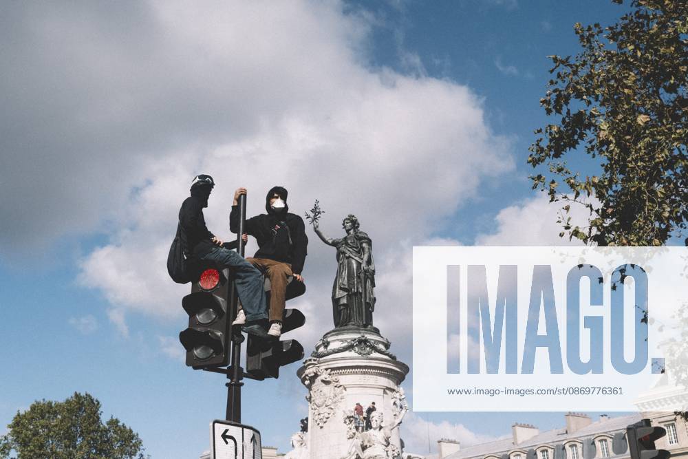 Masked protesters sit on top of a traffic light next to the Monument to the Republic at Place de la Republique in Paris. A national day of mobilization against the high cost of living took place across France on October 17, 2026, joined by Yellow Vests, high school and university students, trade unions, farmers and taxi drivers. In Paris, clashes with police broke out at Place de la Republique even before the march, due to leave at 2 p.m. for Place de Clichy, set off, and the police prefecture banned demonstrations in several areas of the city citing serious risks of public disorder. Paris France - ZUMAs392 20261017_zip_s392_066