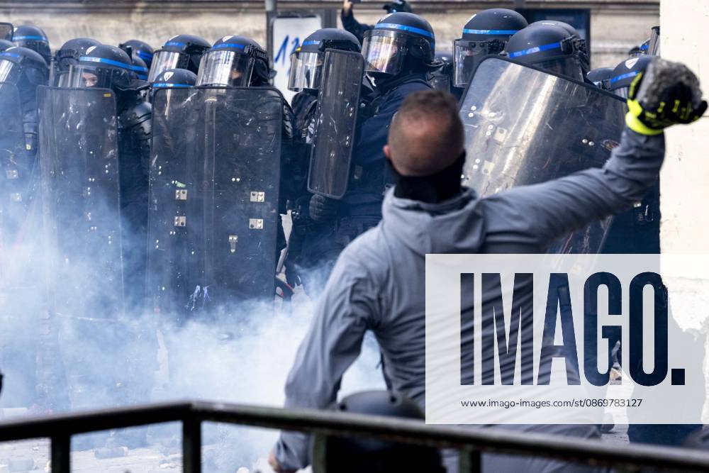 A man throws a chunk of concrete toward a line of riot police amid tear gas during demonstrations in Paris, France, on October 17, 2026. Students and Yellow Vest protesters demonstrated over rising living costs and conditions in education. Paris France - ZUMAl165 20261017_zip_l165_033