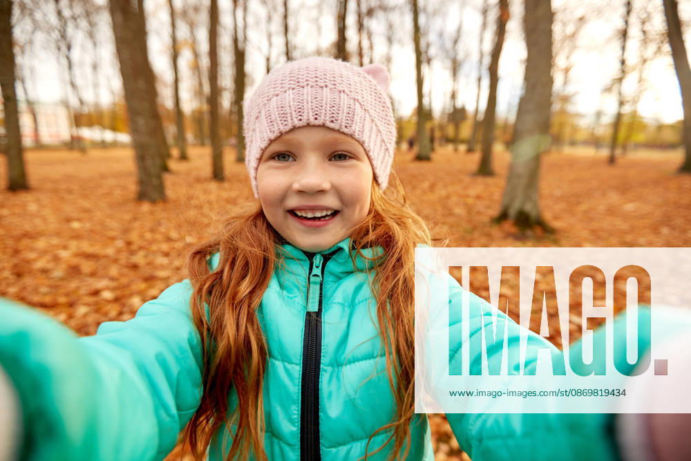 Glücklich mädchen taking selfie im herbst park saison und menschen konzept - glücklich mädchen taking selfie im herbst park (License=RF) ,model released, Symbolfoto