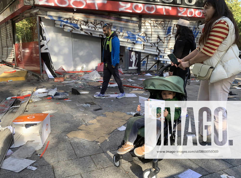 People walk in front of a vandalised shop near Republique Square in Paris, on Sunday, October 18, 2026. Residents awoke to scenes of widespread damage with shopfronts shattered, burnt out cars, charred bikes, and piles of glass and debris on the pavements of the French capital a day after riots erupted during protests against rising fuel prices, the cost of living and deteriorating public services, including schools. PAR20261018112 MAYAxVIDON-WHITE