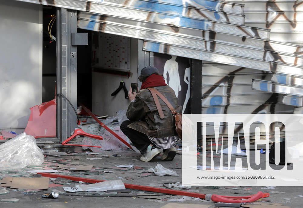 A man takes pictures of a vandalised shop near Republique Square in Paris, on Sunday, October 18, 2026. Residents awoke to scenes of widespread damage with shopfronts shattered, burnt out cars, charred bikes, and piles of glass and debris on the pavements of the French capital a day after riots erupted during protests against rising fuel prices, the cost of living and deteriorating public services, including schools. PAR20261018111 MAYAxVIDON-WHITE