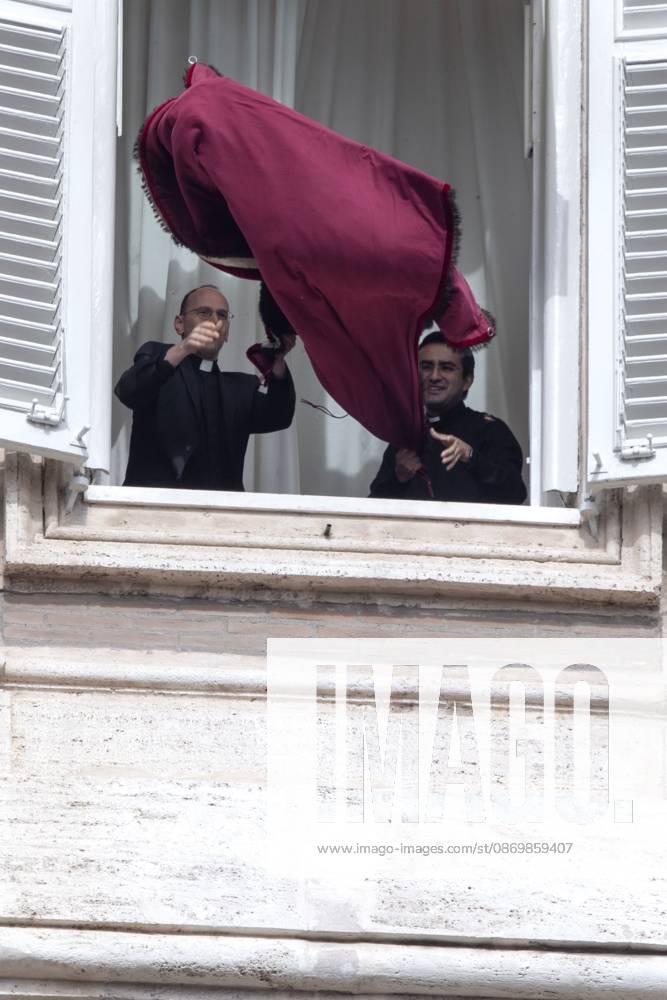 Pope Leo XIV s personal secretaries, Father Marco Billeri and Monsignor Edgard Ivan Rimaycuna Inga, hang a tapestry bearing the pontiff s coat of arms from a window of Pope s study overlooking St. Peter s Square, before the traditional Angelus prayer at the Vatican.Pope Leo XIV during Sunday Angelus Prayer in Vatican Vatican City Vatican - ZUMAs197 20261018_aaa_s197_007