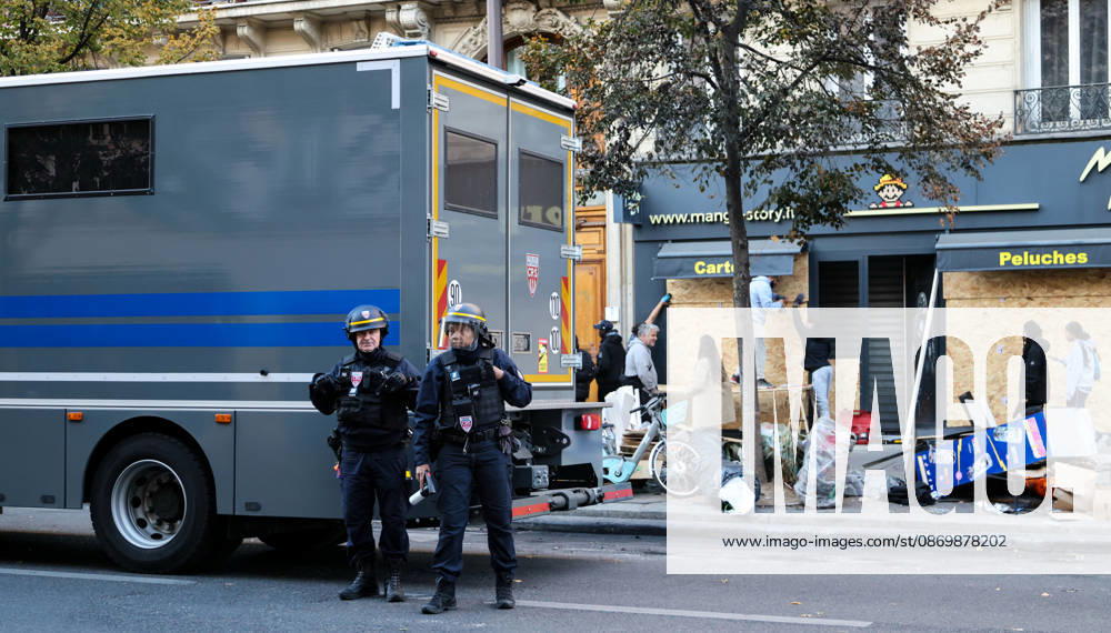 (261018) -- PARIS, Oct. 18, 2026 -- Law enforcement officers stand guard outside a shop in Paris, France, Oct. 18, 2026. French President Emmanuel Macron on Sunday vowed legal action against those responsible for violence during protests across the country on Saturday. ) FRANCE-PARIS-PROTEST-VIOLENCE WuxHuiwo