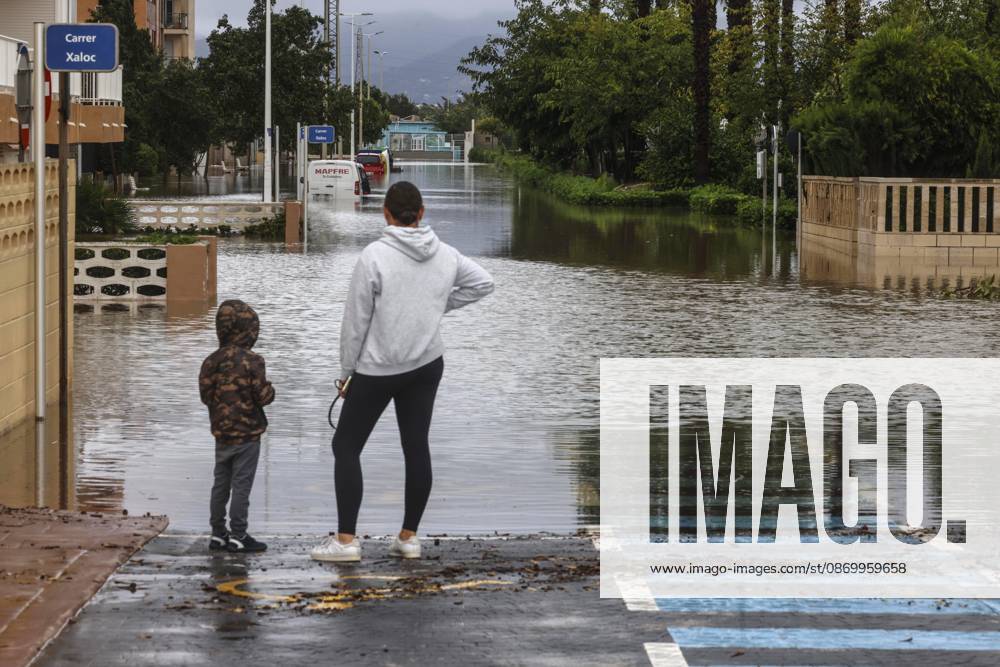 The Valencian Regional Government is preparing a lockdown order for the southern coast of Valencia and the northern coast of Alicante due to the rains. A woman and a child look out over a flooded area on October 19, 2026, in Guardamar de la Safor, Valencia, Valencian Community, Spain. The Valencian Regional Government is preparing a lockdown order for the southern coast of Valencia and the northern coast of Alicante in response to the emergency declared due to the rains brought by Storm Adam, as announced by the Regional Minister of Emergencies and the Interior early this morning, October 19, from the Emergency Coordination Center (CCE) October 19, 2026, Valencia, Valencian Community, Spain
