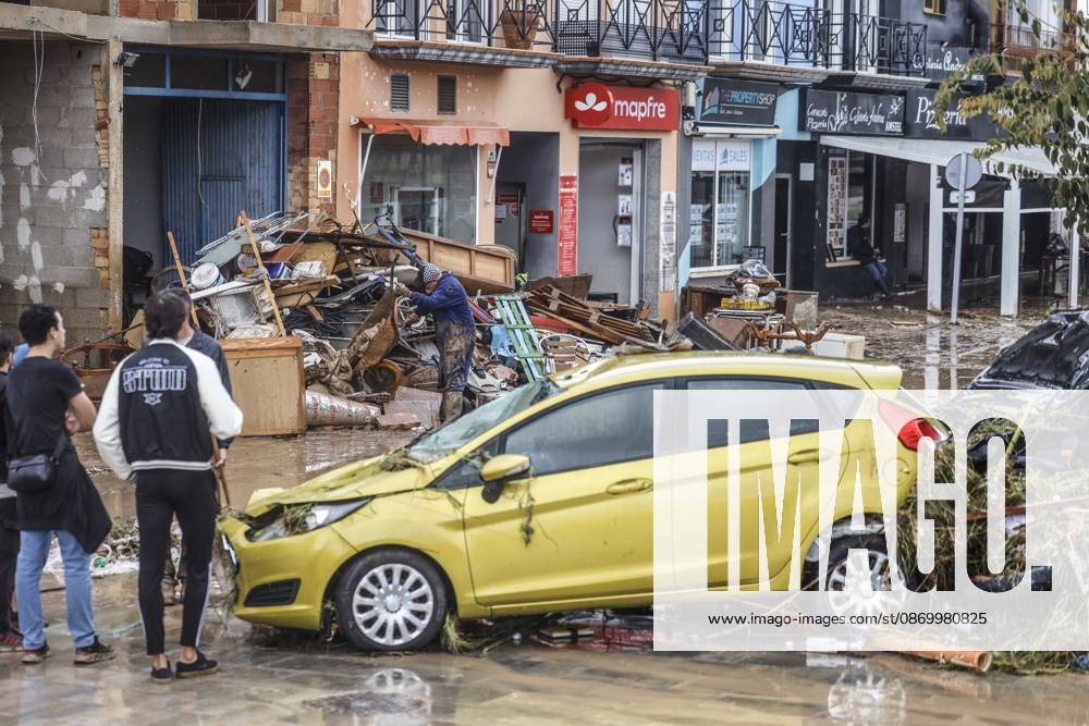 The Valencian Regional Government is preparing a lockdown order for the southern coast of Valencia and the northern coast of Alicante due to the rains. Several people are clearing mud from the streets while furniture they had to remove due to flooding caused by the heavy rains piles up, on October 19, 2026, in Els Poblets, Valencian Community, Spain. The Valencian Regional Government is preparing a lockdown order for the southern coast of Valencia and the northern coast of Alicante in response to the emergency declared due to the rains brought by Storm Adam, as announced by the Regional Minister of Emergencies and the Interior early this morning, October 19, from the Emergency Coordination Center (CCE) October 19, 2026, Valencia, Valencian