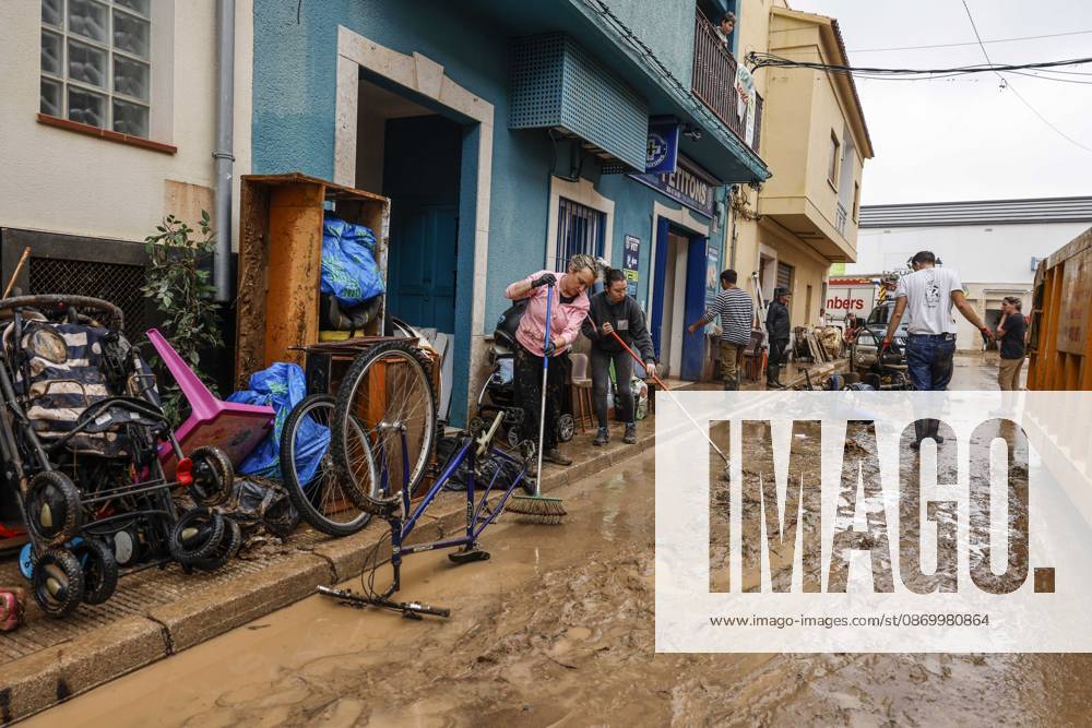 The Valencian Regional Government is preparing a lockdown order for the southern coast of Valencia and the northern coast of Alicante due to the rains. Several people are clearing mud from the streets while furniture they had to remove due to flooding caused by the heavy rains piles up, on October 19, 2026, in Els Poblets, Valencian Community, Spain. The Valencian Regional Government is preparing a lockdown order for the southern coast of Valencia and the northern coast of Alicante in response to the emergency declared due to the rains brought by Storm Adam, as announced by the Regional Minister of Emergencies and the Interior early this morning, October 19, from the Emergency Coordination Center (CCE) October 19, 2026, Valencia, Valencian