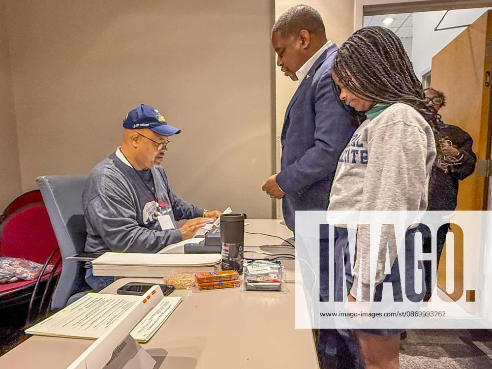 Poll worker JERRY SAXTON checks in Democratic Congressional candidate CHRIS JONES so he can cast his ballot on the first day of early vote in Arkansas. Jones is accompanied in line by his daughter, JASMINE JONES. Jones is running for the seat now held by Rep. French Hill (R-AR). Should Jones win, he will be the first Black person Arkansas sends to Congress. Little Rock USA - ZUMAd155 20261019_znp_d155_027