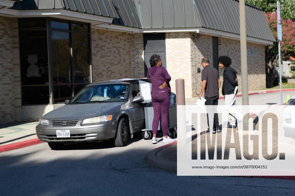 Early voting started in Dallas TX on Monday morning...Martin Luther King Branch Library..An election worker helps a voter cast her ballots curbside. Dallas USA - ZUMAa183 20261019_znp_a183_004