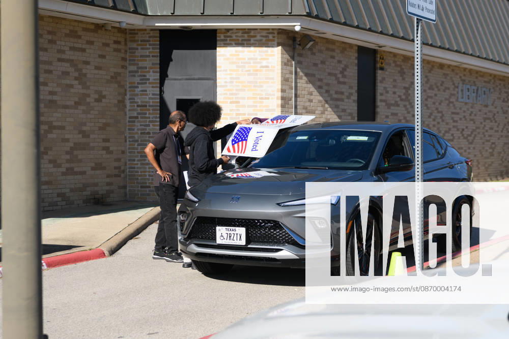 Early voting started in Dallas TX on Monday morning...Martin Luther King Branch Library..An election worker helps a voter cast her ballots curbside. Dallas USA - ZUMAa183 20261019_znp_a183_007