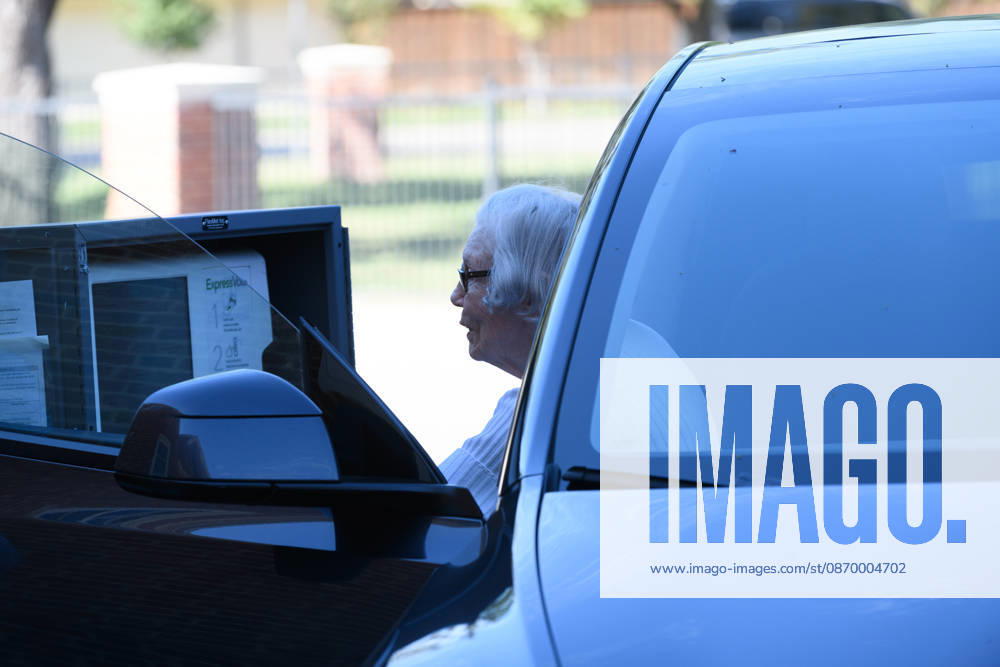 Early voting started in Dallas TX on Monday morning...University Park United Methodist Church..By 1130 am, nearly 700 people voted at this location..Election worker helps a citizen vote curbside. Dallas USA - ZUMAa183 20261019_znp_a183_024