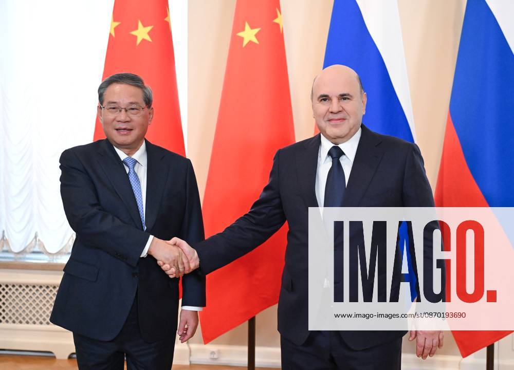 Russia China 9269447 21.10.2026 Chinese Premier Li Qiang and Russian Prime Minister Mikhail Mishustin shake hands as they pose for photos before a narrow format meeting at the Boris Yeltsin Presidential Library in St. Petersburg, Russia. Alexander Miridonov Sputnik St. Petersburg Russia