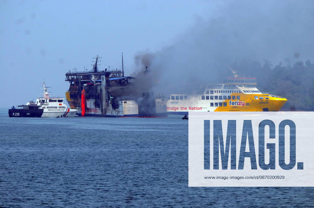 Efforts are underway to extinguish a fire that broke out on a passenger ferry in Indonesia s Cilegon PELABUHAN MERAK, CILEGON, INDONESIA - OCTOBER 21: Fireboats take turns spraying water onto the passenger ferry KMP Batumandi to cool down the vessel after it caught fire while preparing to dock off Merak Port in Cilegon, Banten, Indonesia on Wednesday, October 21, 2026. The vessel caught fire on Tuesday, October 20, and rescue operations remain underway as the ship continues to emit smoke. Water is continuously sprayed to cool the vehicle deck containing numerous cars, motorcycles, buses, and trucks, while authorities confirm no fatalities have been reported. Dasril Roszandi Anadolu Pelabuhan Merak Indonesia. Editorial use only. Please get
