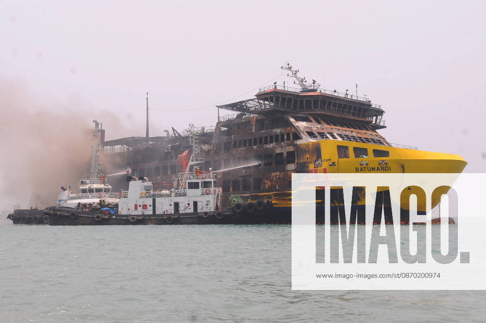 Efforts are underway to extinguish a fire that broke out on a passenger ferry in Indonesia s Cilegon PELABUHAN MERAK, CILEGON, INDONESIA - OCTOBER 21: Fireboats take turns spraying water onto the passenger ferry KMP Batumandi to cool down the vessel after it caught fire while preparing to dock off Merak Port in Cilegon, Banten, Indonesia on Wednesday, October 21, 2026. The vessel caught fire on Tuesday, October 20, and rescue operations remain underway as the ship continues to emit smoke. Water is continuously sprayed to cool the vehicle deck containing numerous cars, motorcycles, buses, and trucks, while authorities confirm no fatalities have been reported. Dasril Roszandi Anadolu Pelabuhan Merak Indonesia. Editorial use only. Please get