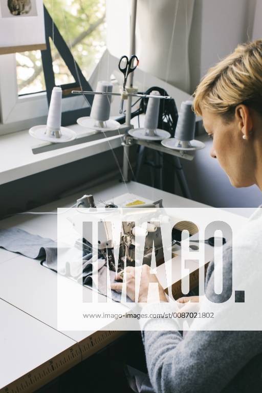 Woman using sewing machine on table in studio model released Symbolfoto property released JUBF00280