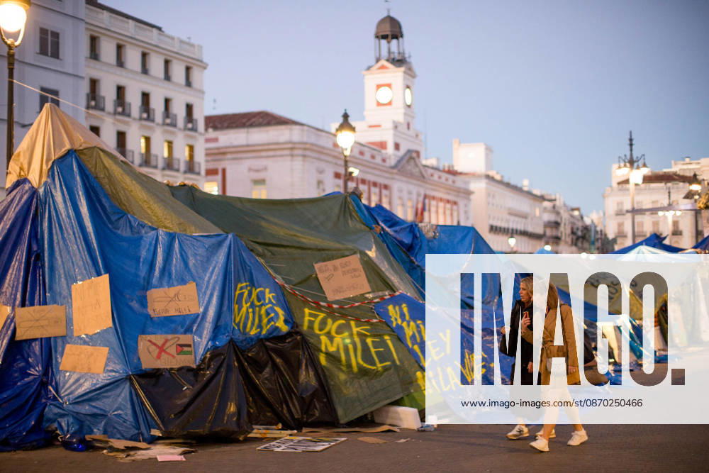 Javier Milei, President of Argentina visits Madrid - 21 Oct 2026 (EDITOR S NOTE: Image depicts profanity) Two women walk past graffiti opposing Javier Milei’s visit to Spain, near a campsite in the center of Madrid. Javier Milei, President of Argentina is the guest of honor at a breakfast briefing organized by the New Economy Forum located just a few meters from the Puerta del Sol in the heart of Madrid. Madrid Spain