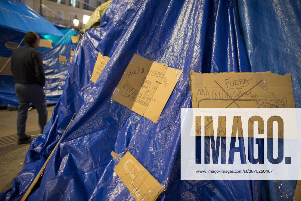 Javier Milei, President of Argentina visits Madrid - 21 Oct 2026 A man walks past placard on a tent protesting against Javier Milei’s visit to Spain, near an encampment in the center of Madrid. Javier Milei, President of Argentina, is the guest of honor at a breakfast briefing organized by the New Economy Forum located just a few meters from the Puerta del Sol in the heart of Madrid. Madrid Spain
