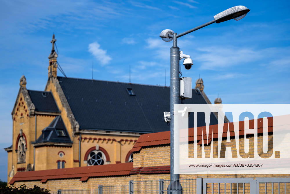 Germany, Saxony, Bautzen: A surveillance camera and a streetlight in front of the historic buildings of the Bautzen Correctional Facility in Saxony. The prison complex is secured by walls and security fences.
