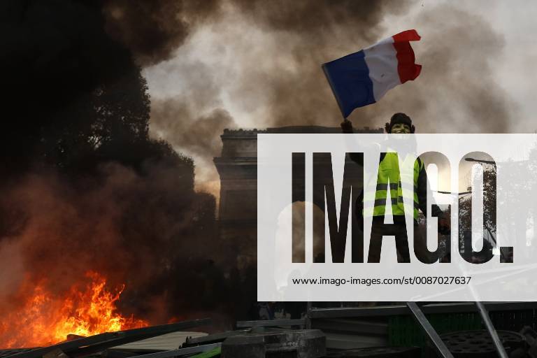 Frankreich, Ausschreitungen auf der Champs-Elysees in Paris November 24, 2018 - Paris, Ile-de-France, France - Yellow vests (Gilets jaunes) protestors shout slogans as material burns during a protest against rising oil prices and living costs near the Arc of Triomphe on the Champs Elysees in Paris, on November 24, 2018. .Police fired tear gas and water cannon on November 24 in central Paris against yellow vest protesters demanding French President Emmanuel Macron roll back tax hikes on motor fuel. ( Nurphoto) Paris France - ZUMAn230 20181124_zaa_n230_495
