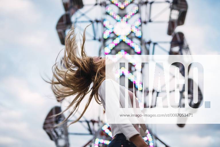 Long-haired young woman shaking her hair on a funfair model released Symbolfoto KKAF02015
