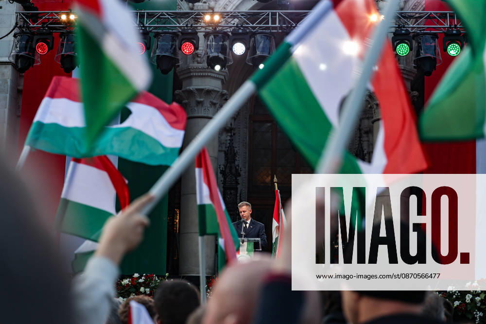 Hungarian revolutionary flags fill the foreground as Prime Minister PETER MAGYAR looks down at the podium during his first October 23 commemorative address as prime minister, marking the 70th anniversary of the 1956 Hungarian Revolution outside Parliament. Budapest Hungary - ZUMAo116 20261023_znp_o116_067