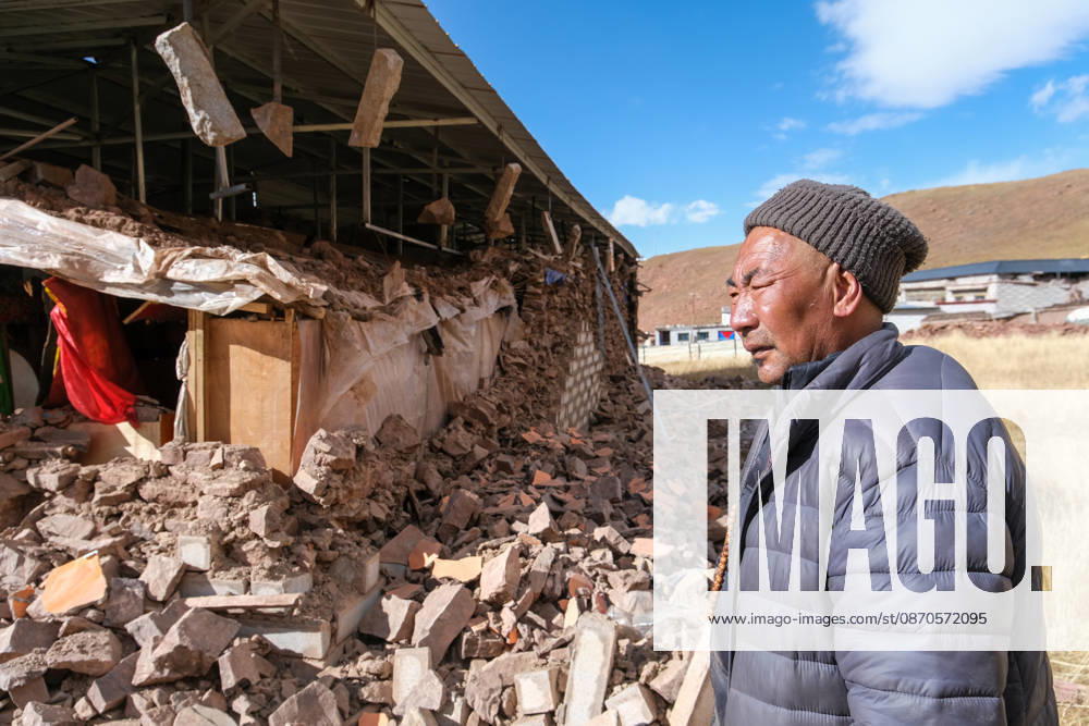 A farmer and herder stands in front of his damaged home on October 24, 2026 in Nagqu, Xizang Autonomous Region of China. More than 5,000 personnel have been deployed to the front lines of the disaster relief operation, working in teams responsible for search and rescue, medical treatment, temporary shelter and the provision of essential supplies.