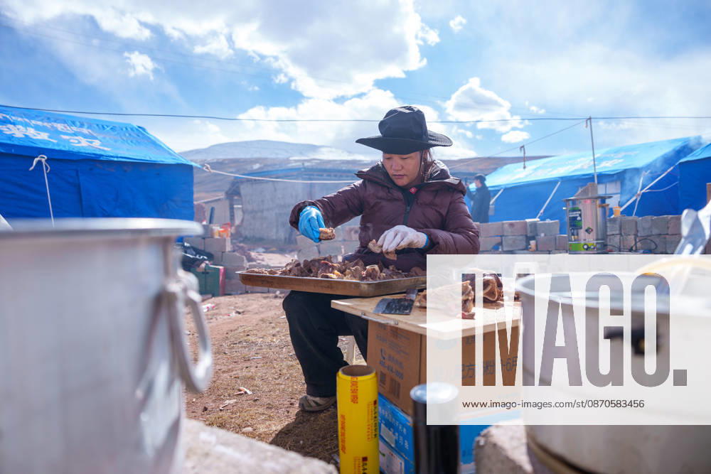 (261024) -- NAGQU, Oct. 24, 2026 -- A staff member of the local government prepares food at a quake-hit village in Maru Township of Baqen County, Nagqu City, southwest China s Xizang Autonomous Region, Oct. 24, 2026. As of 11 a.m. Saturday, 52,450 items or sets of disaster relief supplies had been sent to the quake zone, while more than 2,500 rescue personnel were engaged in relief operations. Authorities have established 35 temporary resettlement sites in the disaster zone. Medical treatment and public health and epidemic prevention efforts are proceeding in an orderly manner, according to the local emergency command headquarters. ) (SpotNews) CHINA-XIZANG-NAGQU-EARTHQUAKE-RELIEF WORK (CN) TenzinxNyida