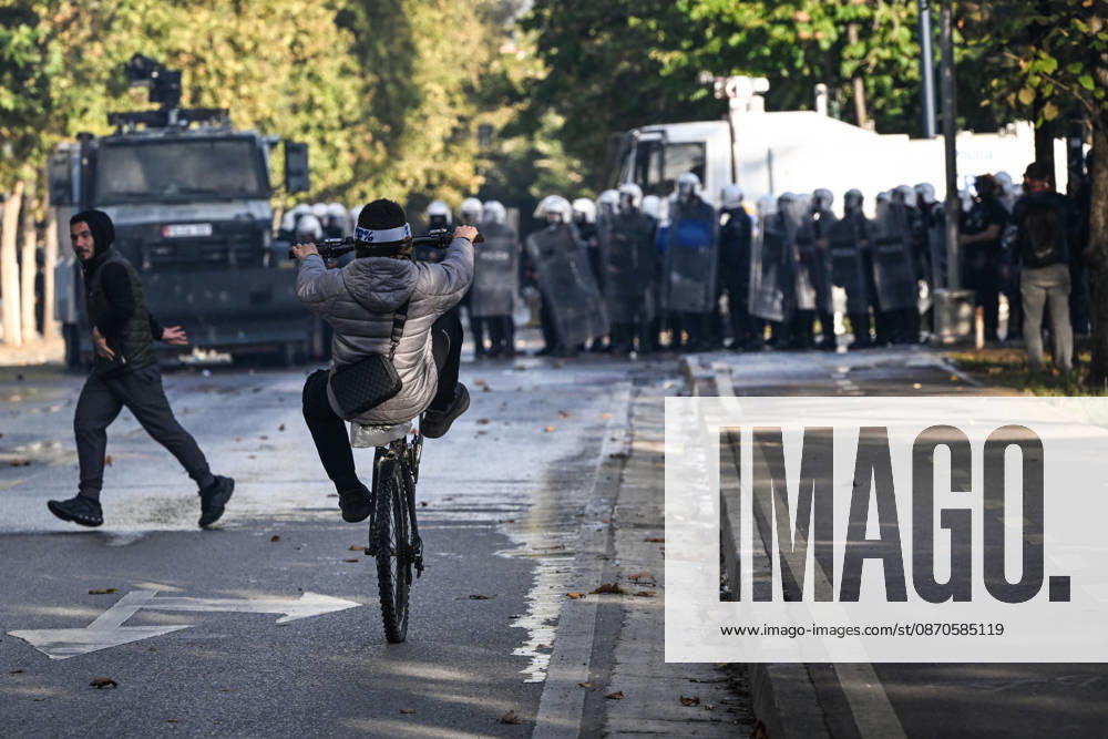 Mass Anti-Government National Protest in Tirana TIRANA, ALBANIA - OCTOBER 24: A young cyclist performs a wheelie on a wet street while moving away from an advancing line of riot police shields and armored vehicles on October 24, 2026, in Tirana, Albania. Unrest and physical confrontations erupt in Tirana city center as demonstrators and riot police clash during a massive nationwide protest, turning the capital s main avenue into a major flashpoint as chaotic skirmishes broke out between security forces and factions of the crowd. Artur Widak Anadolu Tirana Albania. Editorial use only. Please get in touch for any other usage.