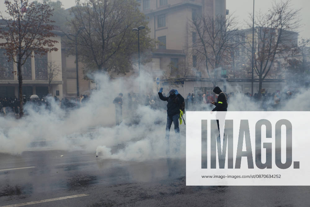 Paris Street Protest Demonstrators stand amid tear gas drifting across a street in Paris, France on October 24, 2026. Authorities deployed around 70,000 security personnel across France for renewed protests over the cost of living on October 24, after unrest a week earlier saw public buildings vandalized, hundreds of shops looted and about 2,700 people arrested. Paris Ile de France France