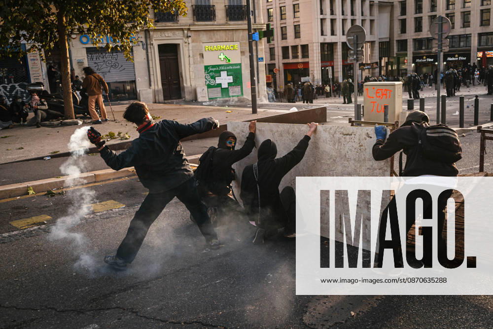 Marseille France Street Protests Protesters take cover behind a wooden barrier while a tear gas canister releases smoke during a protest in Marseille, France on October 24, 2026. Authorities deployed around 70,000 security personnel across France for renewed protests over the cost of living, after unrest a week earlier saw public buildings damaged, hundreds of shops looted and about 2,700 people arrested. Marseille Provence-Alpes-CÃ te France