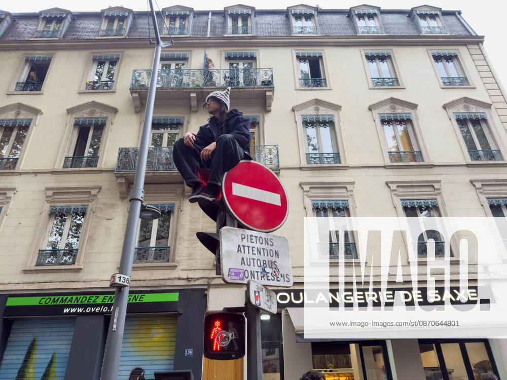 Lyon France Protests October 24 A demonstrator sits atop a traffic signal during a protest in Lyon, France on October 24, 2026. Authorities deployed around 70,000 security personnel across France for renewed protests over the cost of living, after unrest a week earlier saw public buildings damaged, hundreds of shops looted and about 2,700 people arrested. Lyon Rhone Alpes France