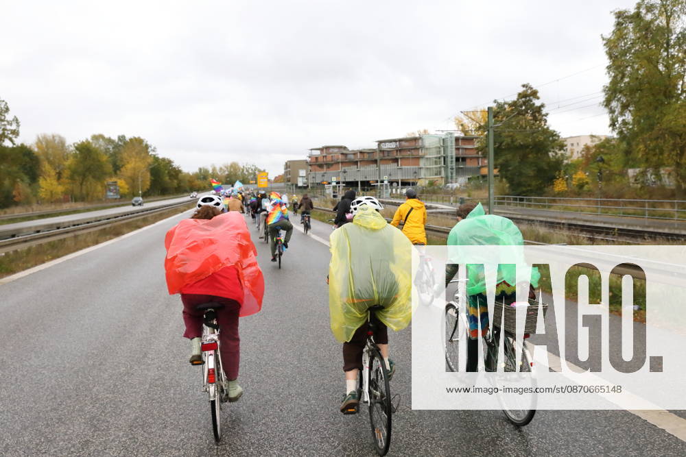 Protesters wearing colorful rain capes ride down Nuthestraße heading out of town during Bike Pride in Potsdam, October 24, 2026 Bike Pride Potsdam