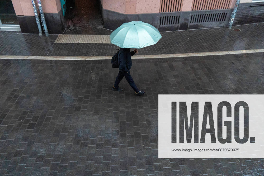 A person walks with an umbrella in the rain in Frankfurt am Main, Germany. Frankfurt Germany - ZUMAb332 20261025_zip_b332_003