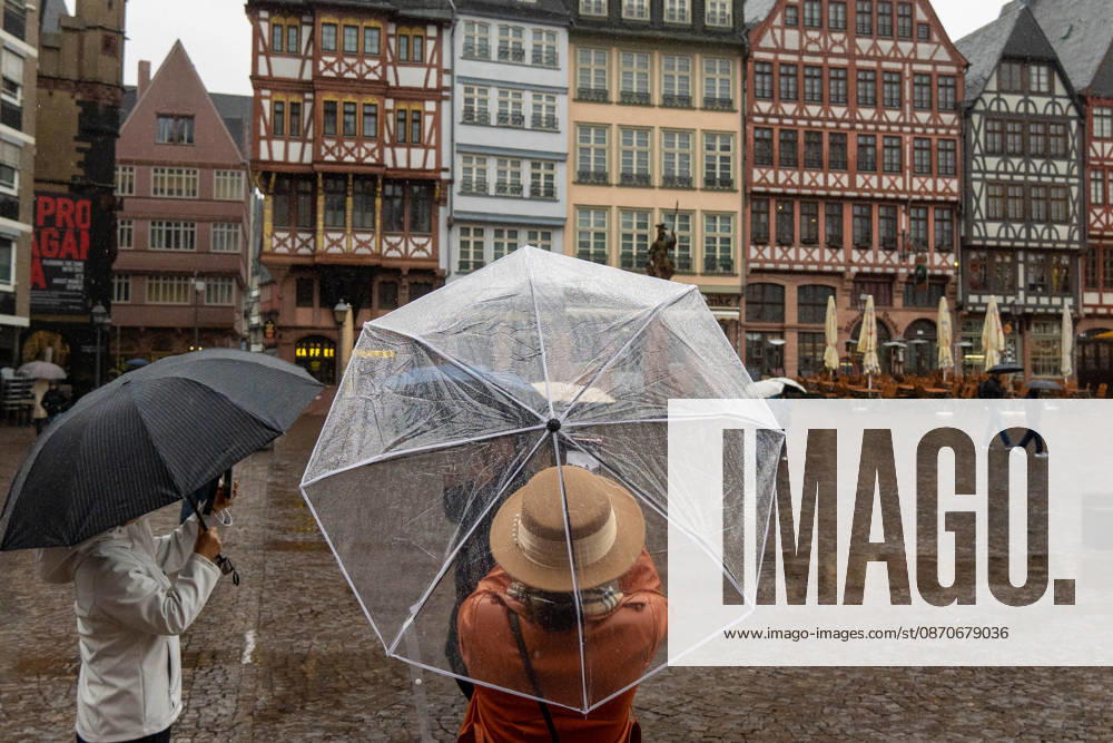 Tourists take photographs on a rainy day in Frankfurt am Main, Germany. Frankfurt Germany - ZUMAb332 20261025_zip_b332_005