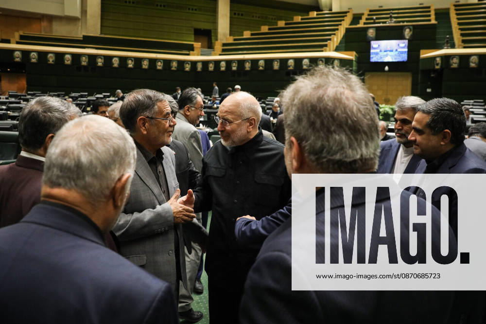 Mohammad Bagher Ghalibaf exchanges greetings with a small circle of suited men in the parliamentary chamber at the Islamic Consultative Assembly in Tehran, Iran, on October 25, 2026. The Iranian parliament held a hybrid open sitting, with some lawmakers attending in the Tehran chamber and others participating remotely, according to parliamentary reports. Tehran Iran - ZUMAi98_ 20261025_zih_i98_033