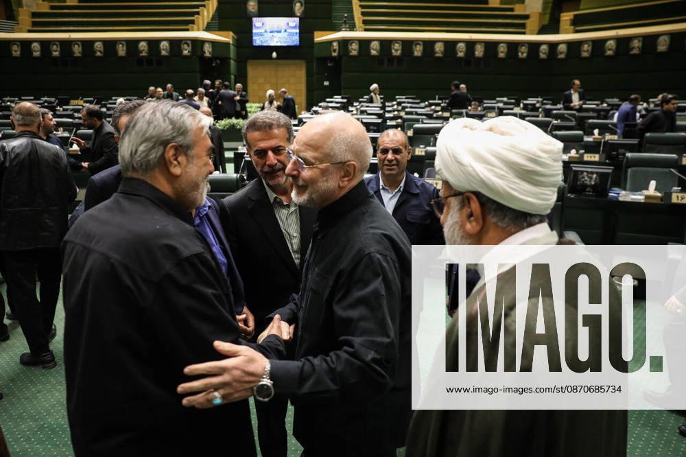 Mohammad Bagher Ghalibaf talks animatedly to a gray-haired man in a dark jacket as a cleric stands beside them at the Islamic Consultative Assembly in Tehran, Iran, on October 25, 2026. Speaker Mohammad Bagher Ghalibaf chaired the October 25 session, which combined physical attendance at the Islamic Consultative Assembly with participation by video link. Tehran Iran - ZUMAi98_ 20261025_zih_i98_039