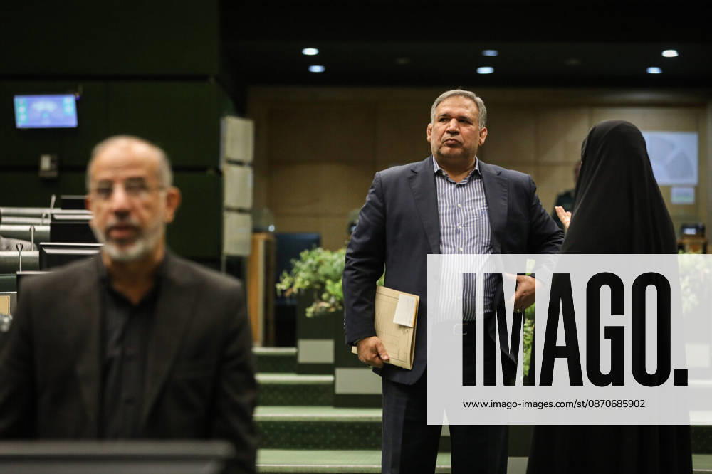A suited man carrying a folder stands talking to a woman in a black chador near an entrance to the parliament chamber at the Islamic Consultative Assembly in Tehran, Iran, on October 25, 2026. The Iranian parliament held a hybrid open sitting, with some lawmakers attending in the Tehran chamber and others participating remotely, according to parliamentary reports. Tehran Iran - ZUMAi98_ 20261025_zih_i98_052
