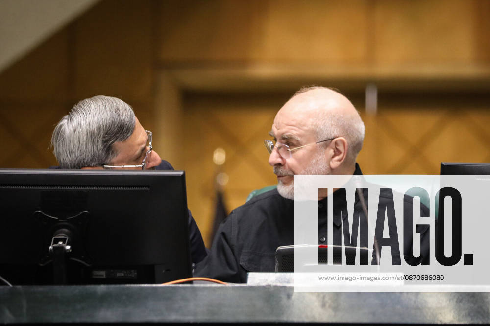 Mohammad Bagher Ghalibaf turns toward a gray-haired man speaking to him from behind a computer monitor at the Islamic Consultative Assembly in Tehran, Iran, on October 25, 2026. Parliamentary reports said more than two-thirds of lawmakers joined the October 25 open sitting of the Islamic Consultative Assembly, attending either in person or remotely. Tehran Iran - ZUMAi98_ 20261025_zih_i98_078