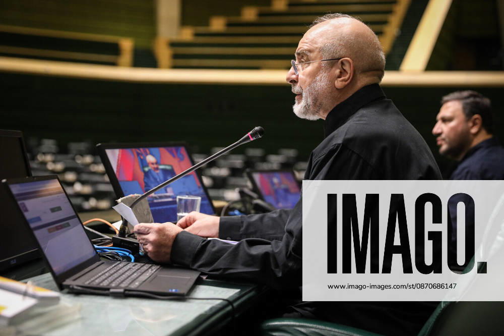 Mohammad Bagher Ghalibaf consults papers beside an open laptop and microphones at the presiding desk at the Islamic Consultative Assembly in Tehran, Iran, on October 25, 2026. Parliamentary reports said more than two-thirds of lawmakers joined the October 25 open sitting of the Islamic Consultative Assembly, attending either in person or remotely. Tehran Iran - ZUMAi98_ 20261025_zih_i98_095
