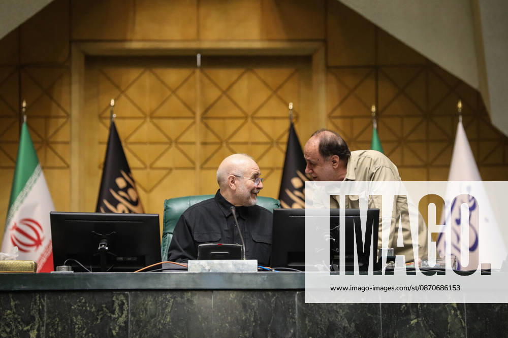 Mohammad Bagher Ghalibaf turns toward a man in a beige shirt leaning over the presiding desk at the Islamic Consultative Assembly in Tehran, Iran, on October 25, 2026. The Iranian parliament held a hybrid open sitting, with some lawmakers attending in the Tehran chamber and others participating remotely, according to parliamentary reports. Tehran Iran - ZUMAi98_ 20261025_zih_i98_097