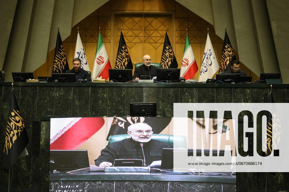Mohammad Bagher Ghalibaf presides beneath Iranian and parliamentary flags while his image appears on a large display below the desk at the Islamic Consultative Assembly in Tehran, Iran, on October 25, 2026. The Islamic Consultative Assembly resumed an open sitting in its Tehran chamber with a mix of in-person and remote participation, according to parliamentary reporting. Tehran Iran - ZUMAi98_ 20261025_zih_i98_105