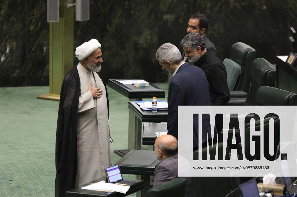 A white-turbaned cleric talks with a man leaning toward him between rows of parliament benches at the Islamic Consultative Assembly in Tehran, Iran, on October 25, 2026. Parliamentary reports said more than two-thirds of lawmakers joined the October 25 open sitting of the Islamic Consultative Assembly, attending either in person or remotely. Tehran Iran - ZUMAi98_ 20261025_zih_i98_110