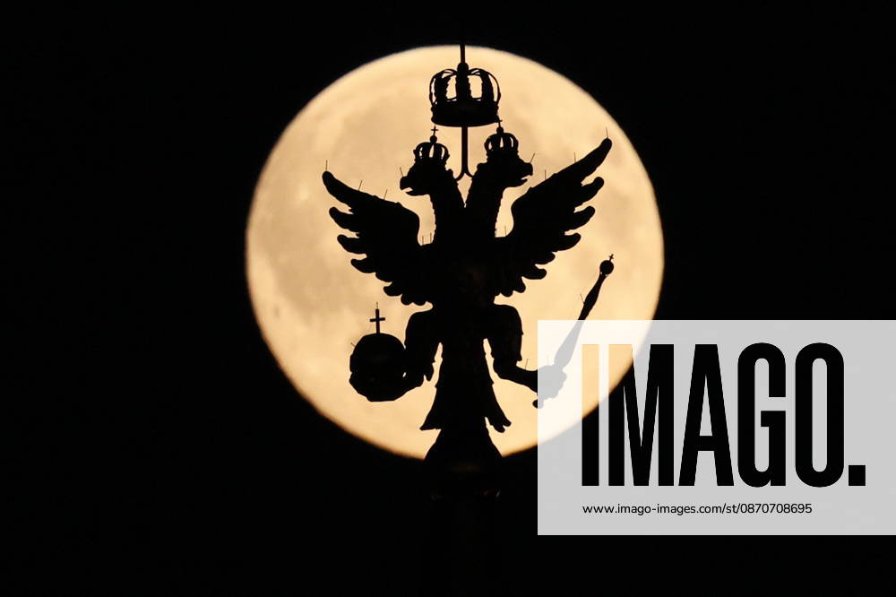 RUSSIA, MOSCOW - OCTOBER 25, 2026: The Russian coat of arms atop a building is silhouetted against the full moon shining over the city Moscow Russia - ZUMAt113 20261025_zaa_t113_325