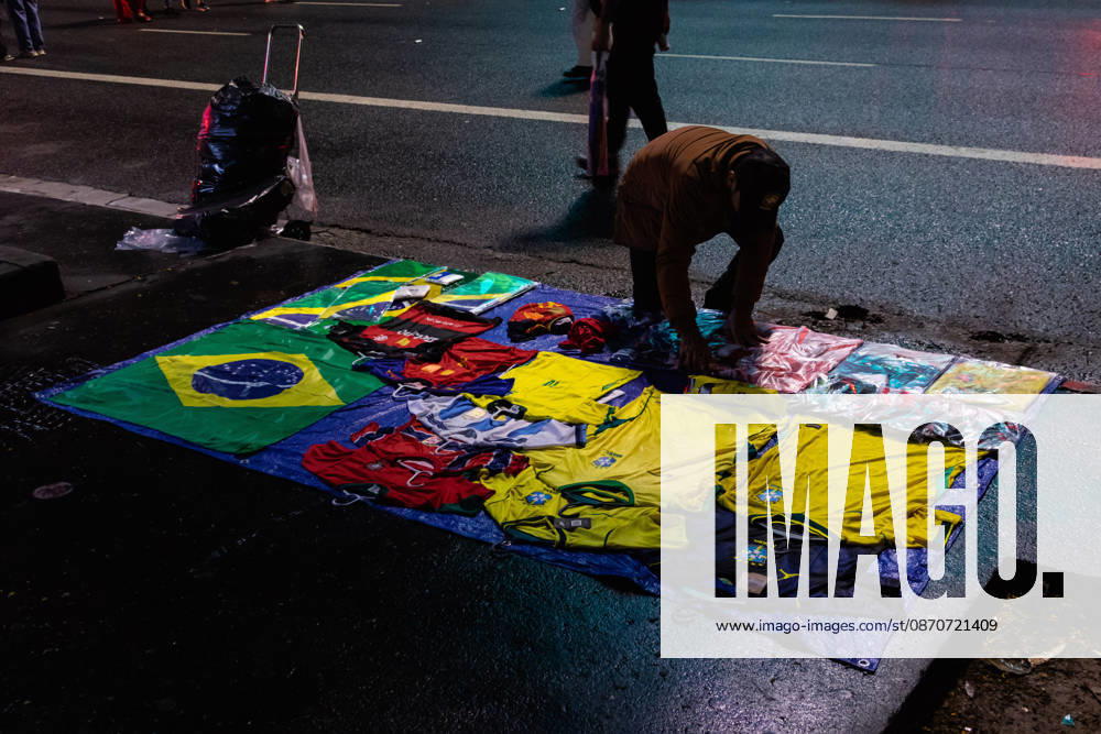 SãO PAULO, SP - 25.10.2026: ELECTION RESULTS ON PAULISTA AVENUE - Supporters of the Workers& 39; Party (PT) gathered on Paulista Avenue to follow the vote count of the second round of the 2026 elections on Sunday night. In the photo: a street vendor sets up a stall in front of the FIESP building. x3039246x WalmorxCarvalho