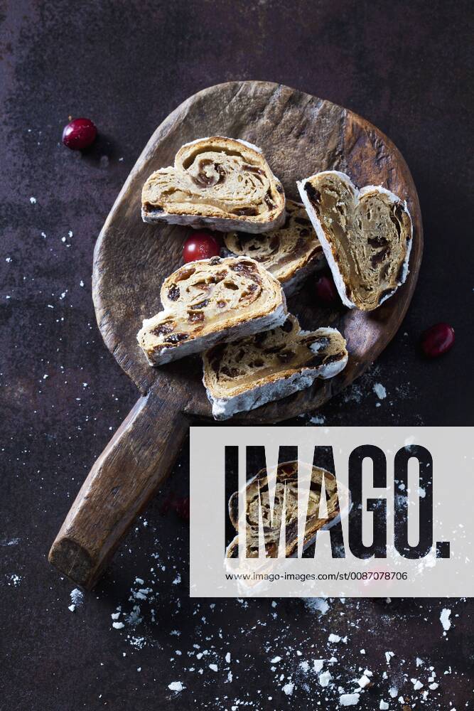 Sliced Christmas Stollen with icing sugar on a wooden scoop CSF28496