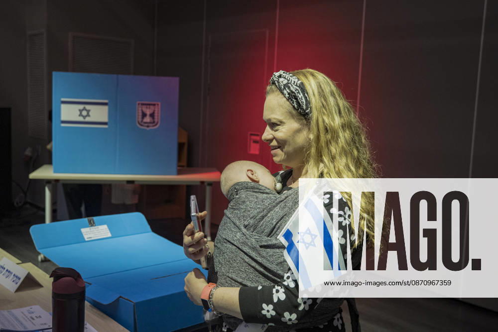 West Jerusalem Israel Parliamentary Elections A woman holds a baby and an Israeli flag beside a ballot box at the Nation Community Center in West Jerusalem, Israel on October 27, 2026. Israelis vote in parliamentary elections to choose the 120 members of the 26th Knesset. West Jerusalem Jerusalem Israel